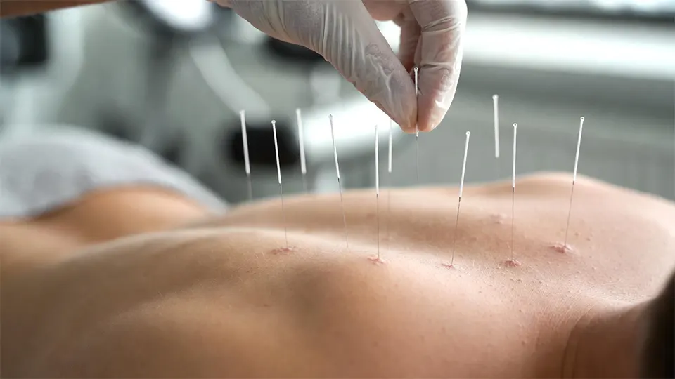 Physiotherapist assisting elderly patient in warm indoor therapy pool, patient performing gentle water exercises, clear blue water, handrails visible, bright indoor aquatic rehab facility, supportive and encouraging atmosphere, natural reflections on water surface, realistic medical photography, 16:9