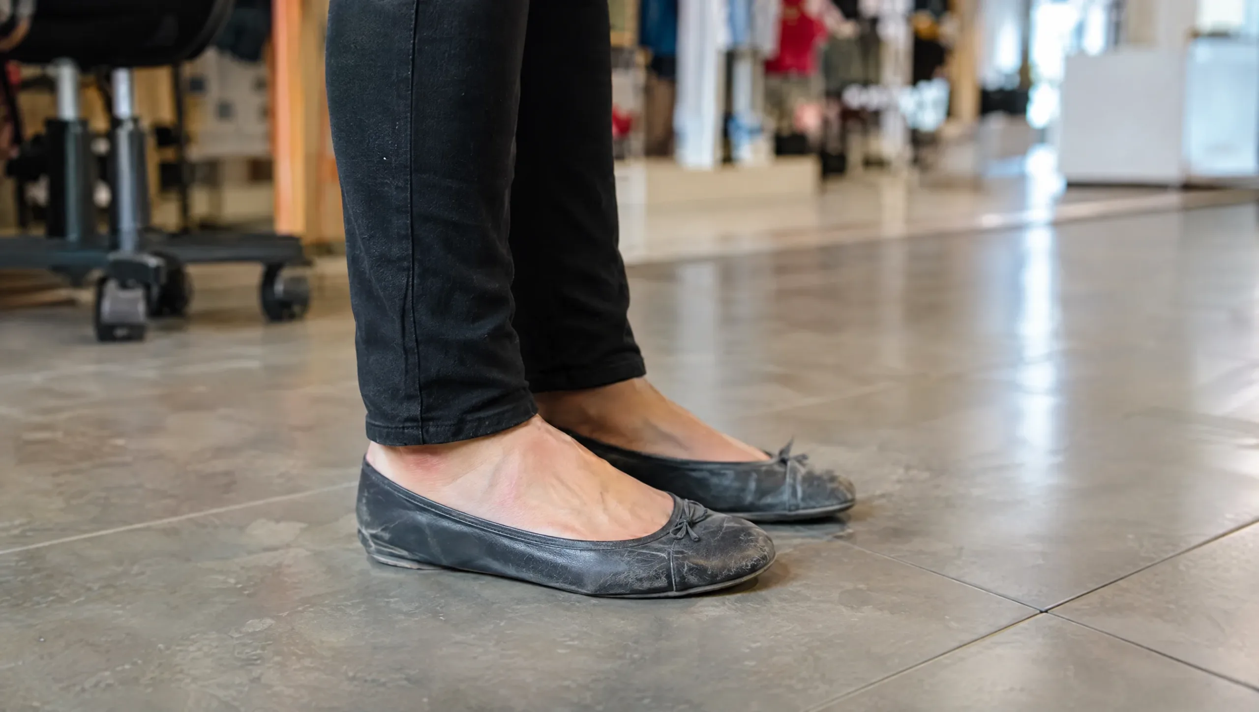 Prolonged standing on hard floors in unsupportive shoes, a common cause of plantar fasciitis