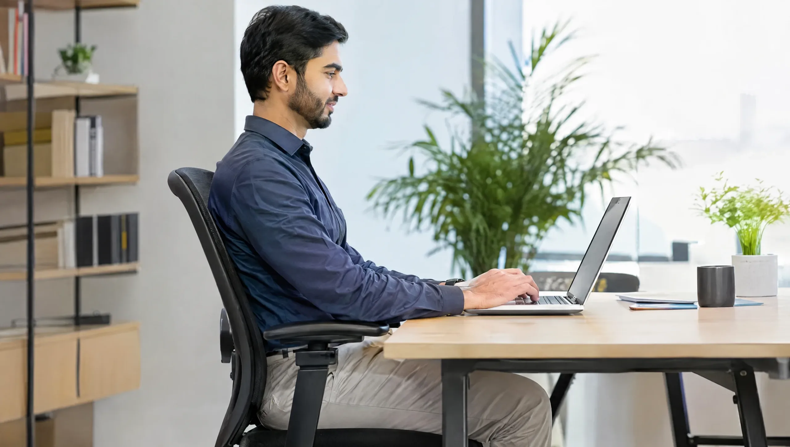 Man demonstrating correct desk posture to prevent chronic neck pain