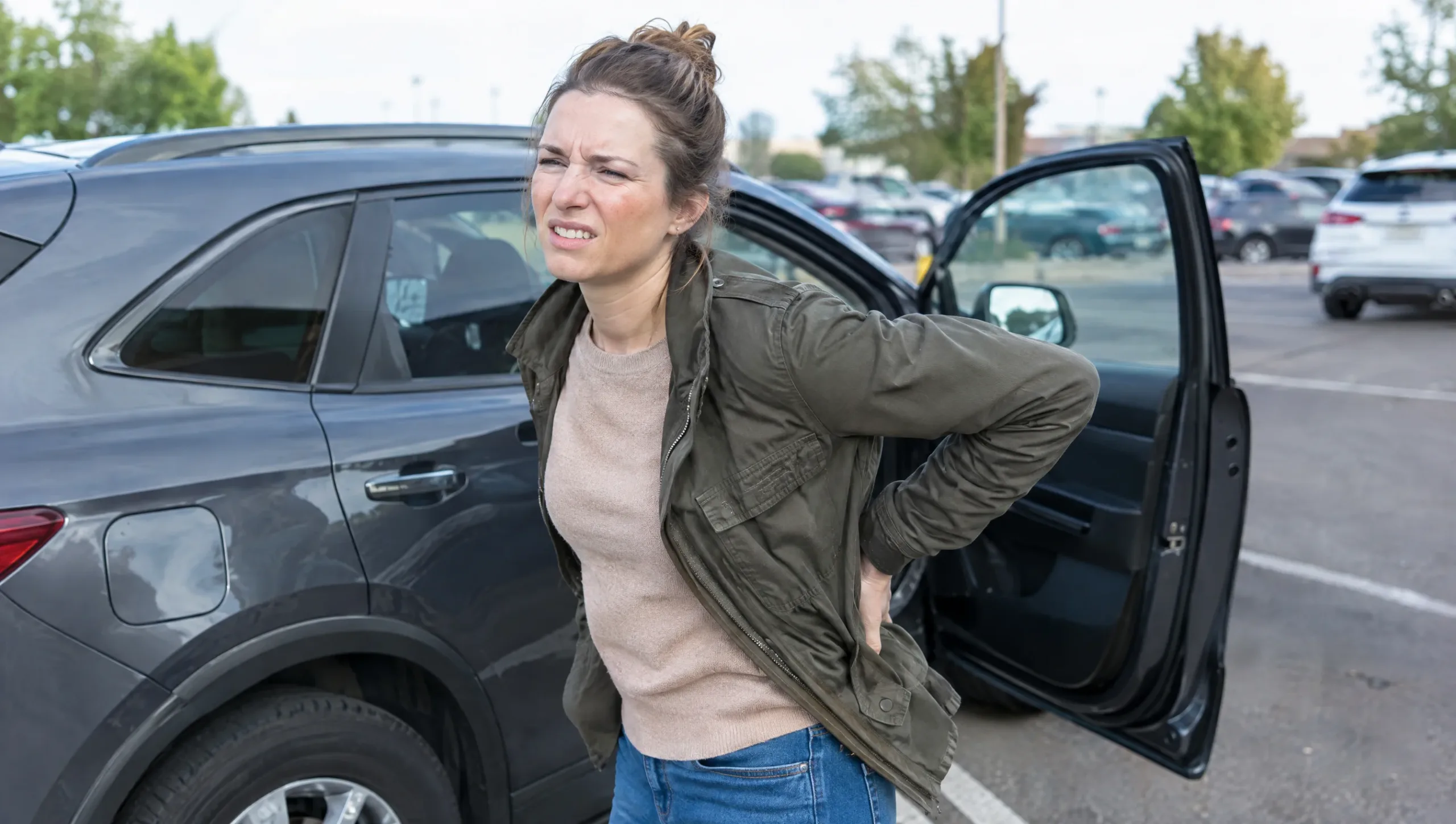 Woman holding her lower back in pain after a long drive