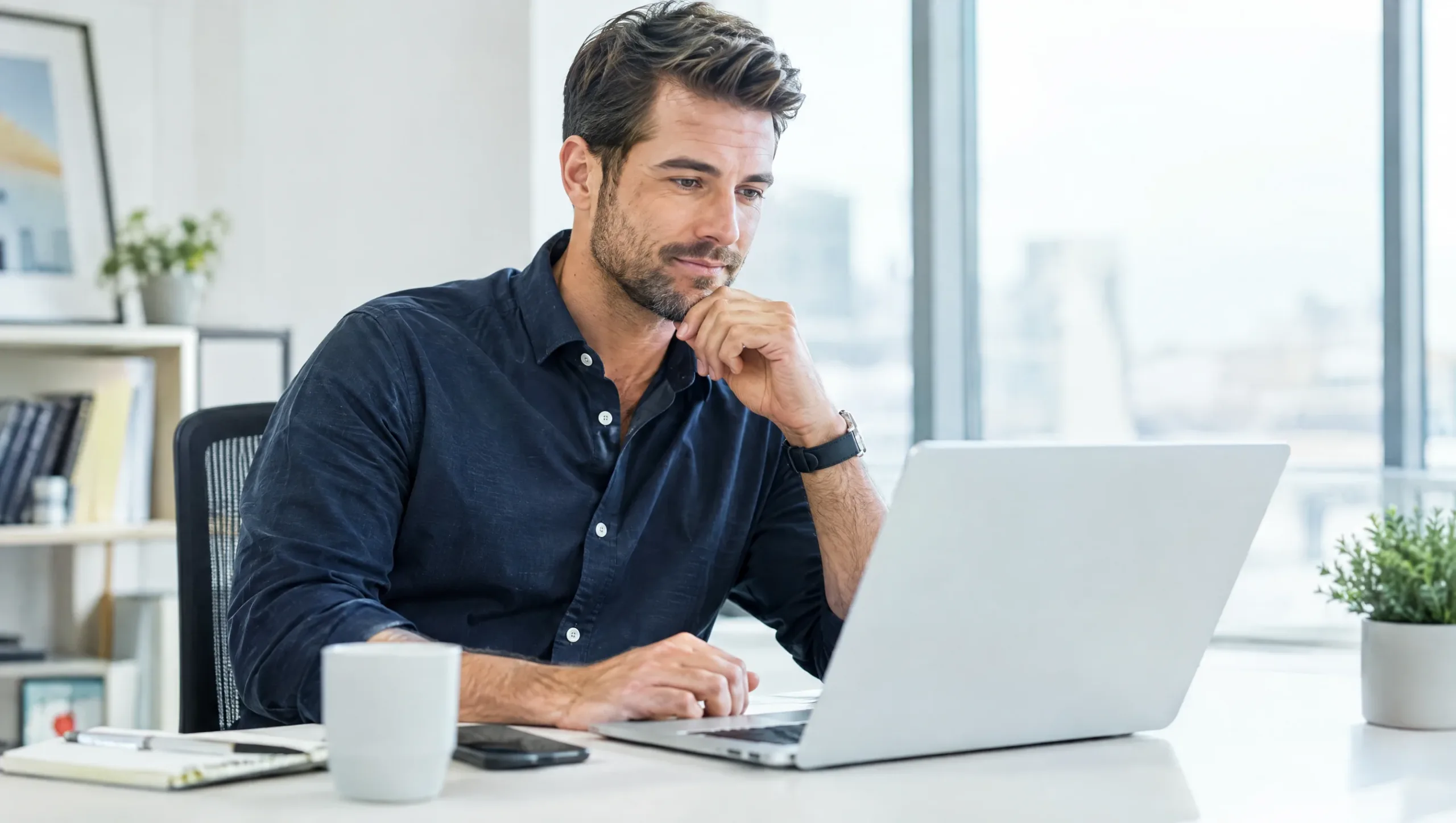 Man reviewing physiotherapy FAQ information at his office desk