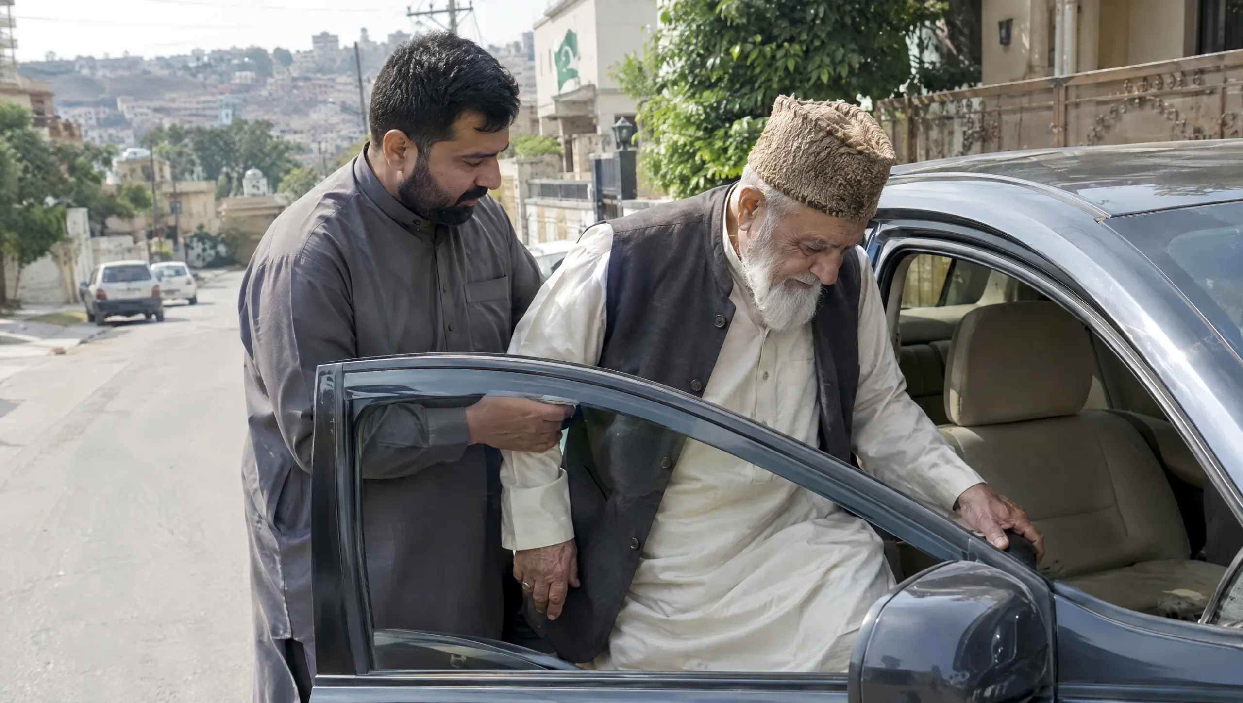 Senior man getting into a car with assistance during month two of recovery from physiotherapy after hip replacement surgery