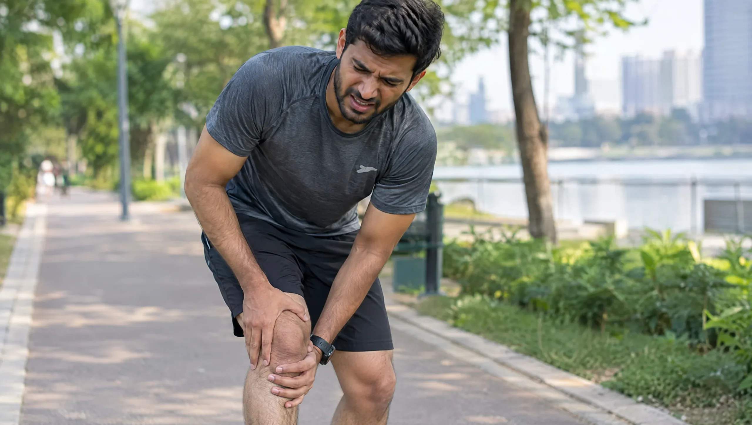 Runner clutching a painful kneecap caused by patellofemoral pain syndrome, known as runner's knee
