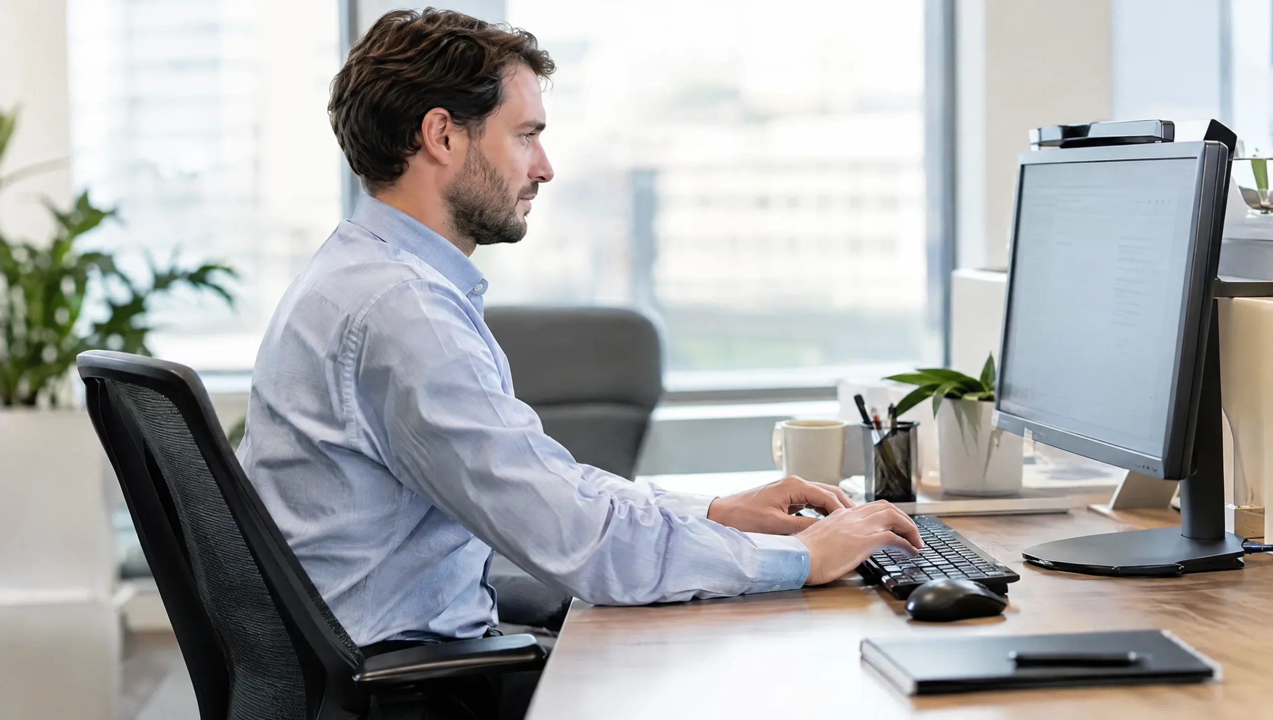Office worker typing for long hours which can contribute to tennis elbow and golfers elbow