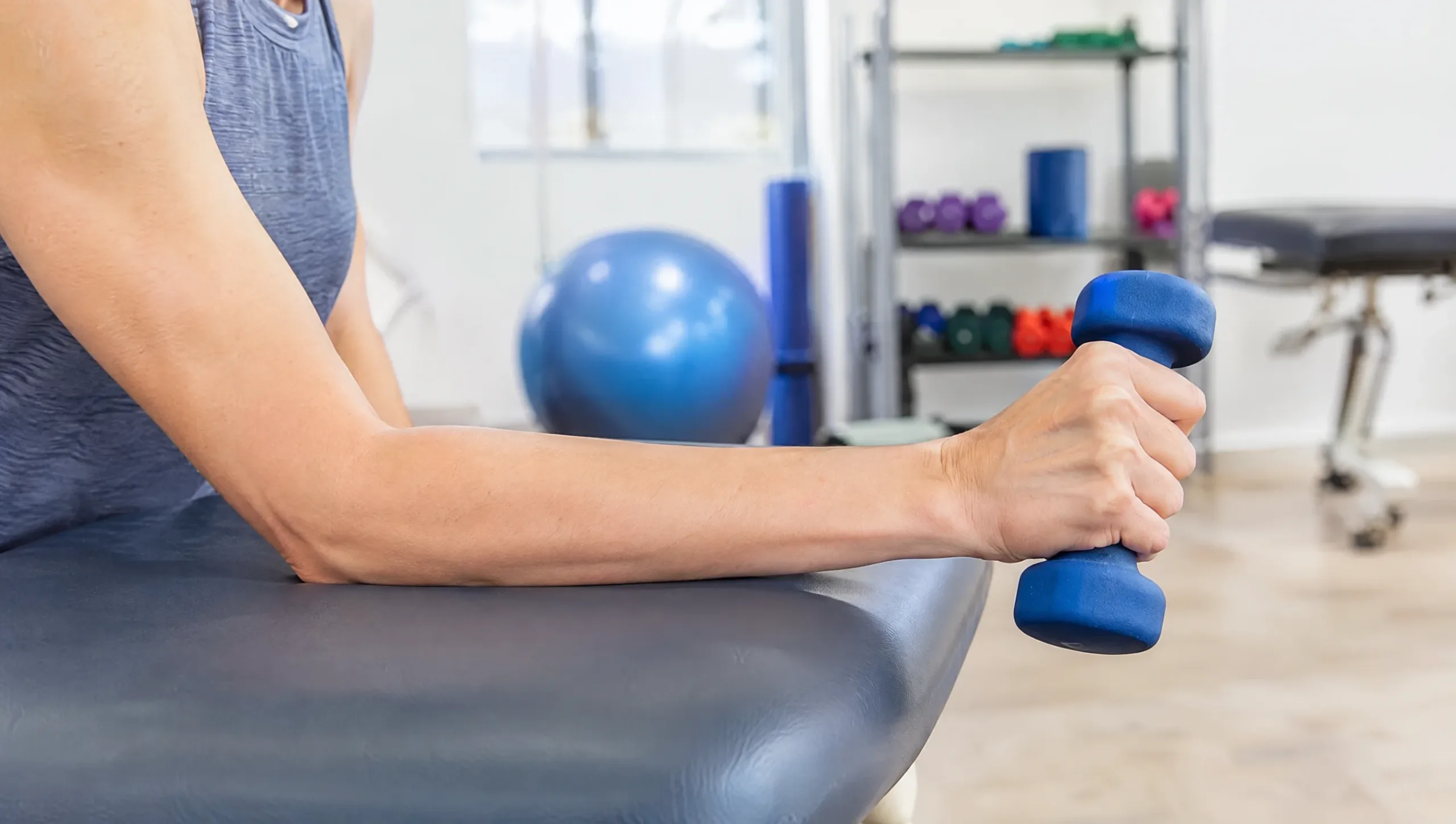 Tennis elbow physiotherapy exercises demonstrated with a light dumbbell during a clinic session