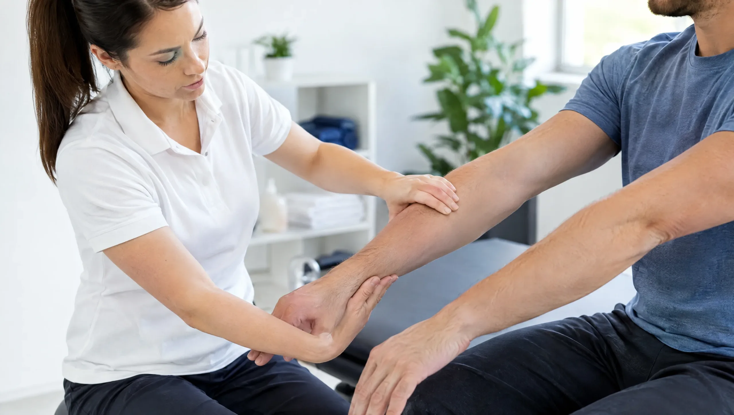 Physiotherapist comparing inside and outside elbow pain to distinguish tennis elbow from golfers elbow