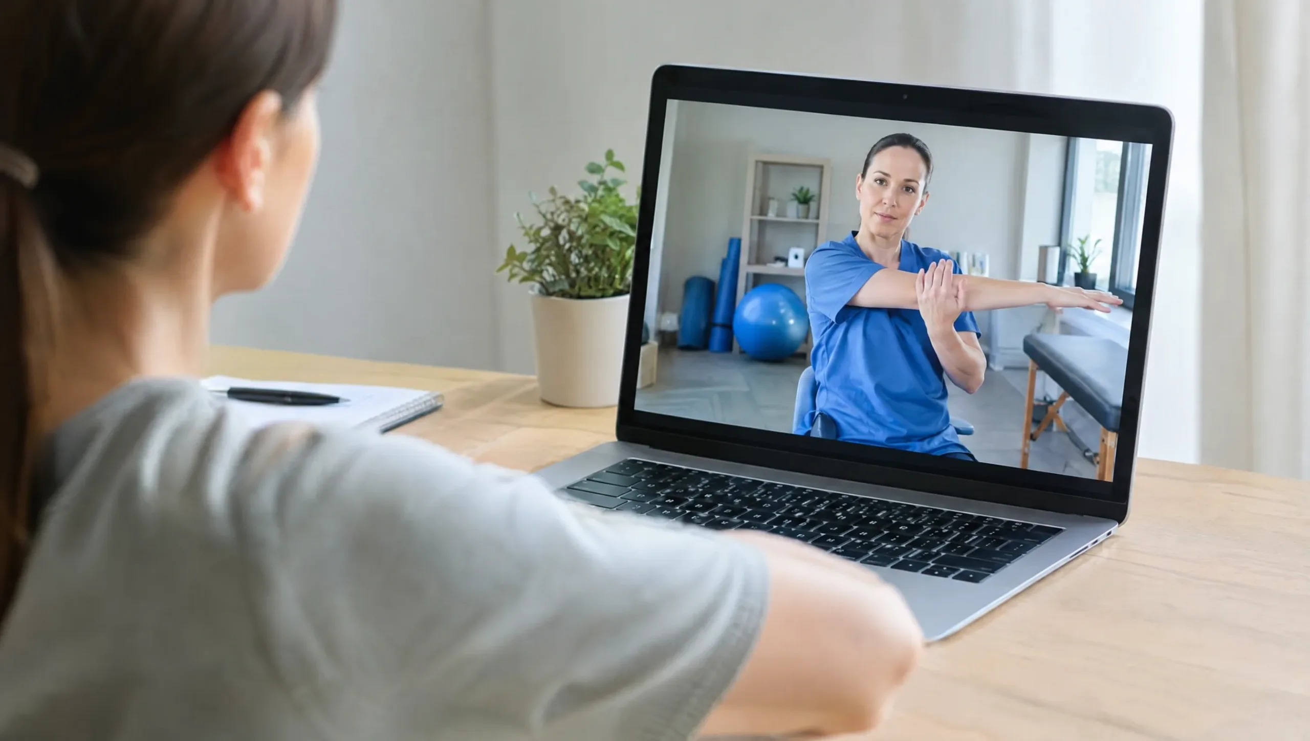 Physiotherapist conducting an online telehealth physiotherapy consultation on a laptop